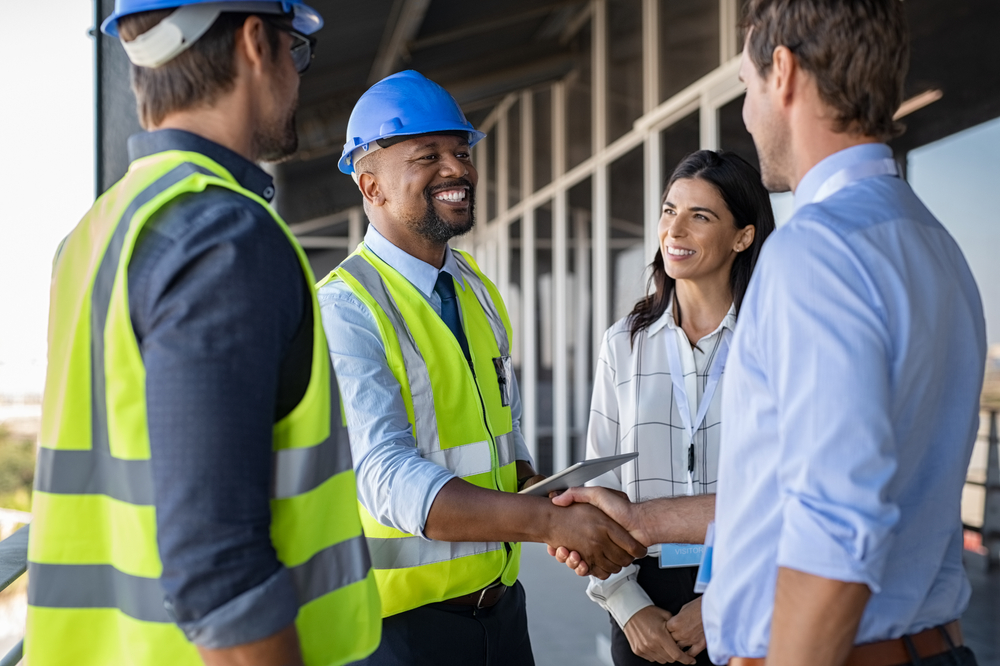 Contractor shaking hands with clients at a job site